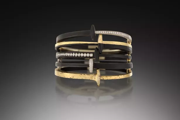 A stack of Pat Flynn's iconic nail bracelets, made with blackened steel, 22k gold, and diamonds.
