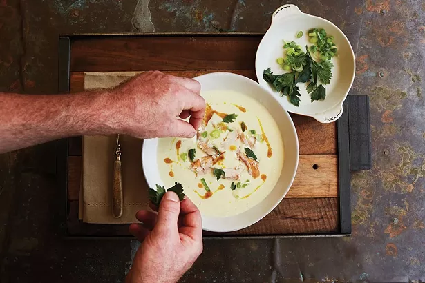 Binnekill Tavern chef Bryan Calvert plating smoked trout soup with crispy parsley. - NATALIE CHITWOOD