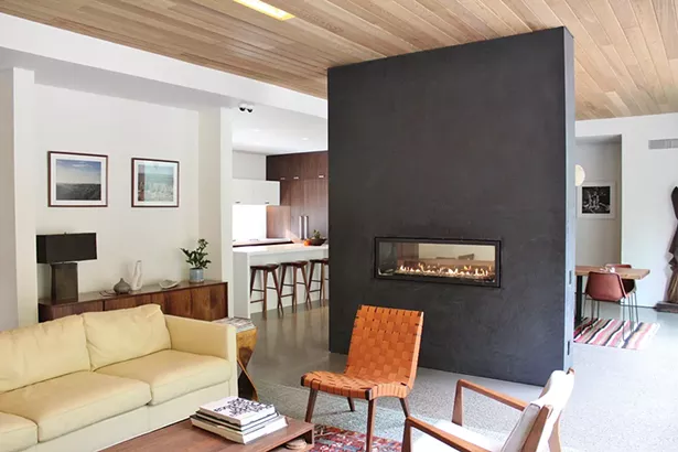 A see-through fireplace serves as a divider between the dining and living areas.