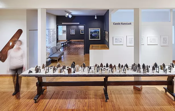 Pressing On installation, 86 antique sad irons on 16’ wooden table by Elizabeth M. Fraser (ca. 1920), Woodstock Artists Association & Museum - PHOTO BY KEVIN KUNSTADT