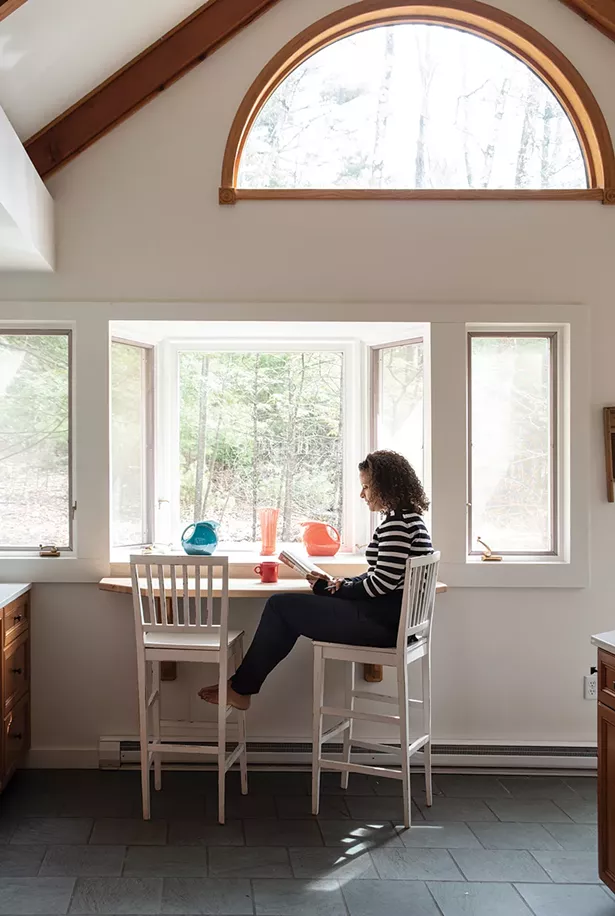 Alison Stewart in the sunny kitchen of her Woodstock retreat overlooking the woods. As of late, the home’s solitude has lent itself well to reading the authors she hosts on her WNYC program “All of It.” “It’s a dream job,” she explains, “especially for a working mom who was an English major. In the past six months, we’ve had 570 guests.” She adds, “I really think if someone has spent all that time working on a book, I should offer them the - courtesy of trying my best to read it.” - PHOTO: DEBORAH DEGRAFFENREID