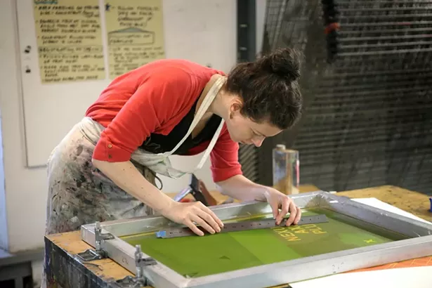 Studio Workspace Resident Sarah McDermott setting up a silkscreen project at the omen's Studio Workshop.