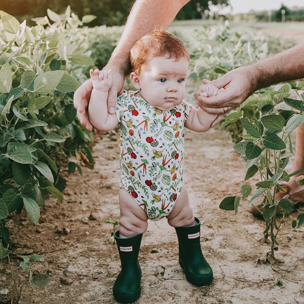 Little Cache wearing the best-selling Veggie Garden Onesie.