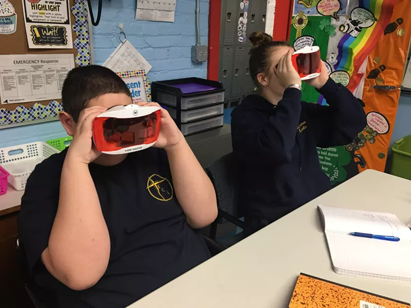 Two seventh-graders use VR googgles in class.