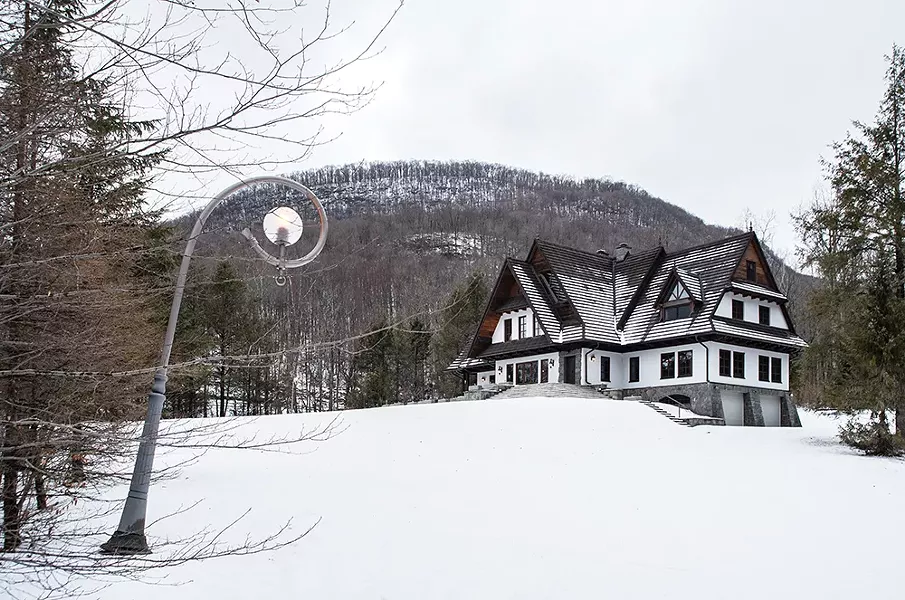 Disassembled and then shipped in crates from Podhale, the castle-like structure was rebuilt on 25 rolling, wooded acres and finally completed in 2005. Eight curved street lamps, also built in - the Zakopane style and shipped from Podhale, line the driveway leading up to the house. - PHOTO BY DEBORAH DEGRAFFENREID