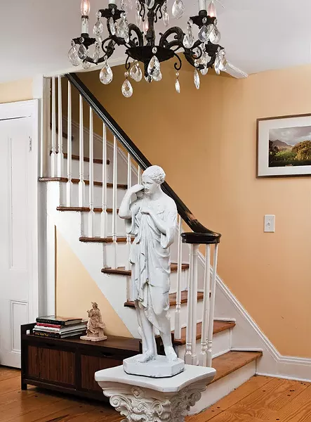 The home’s foyer dates from the 19th century and has low ceilings. “The chandeliers came with the house,” Palaia explains. An antique statue depicting a Roman woman was collected by D’Ambra. Placed under the chandelier, it keeps guests from hitting their heads.