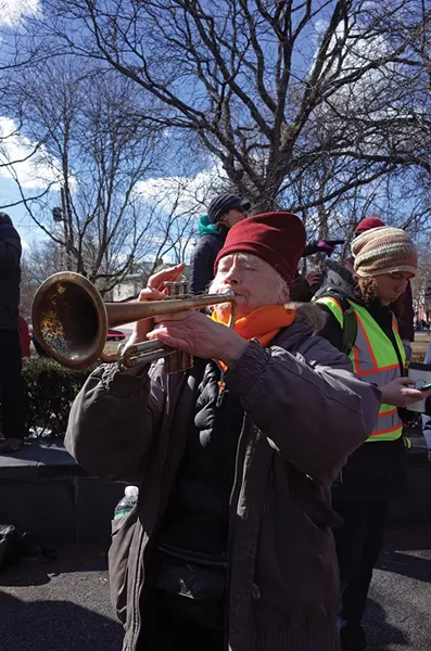 Amy Trompetter sounds a musical protest at the People's March for Education Justice. - FIONN REILLY