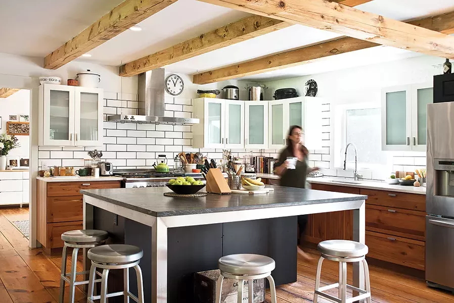 The couple renovated the home’s original kitchen. They hired local blacksmith Jonathan Nedbor to create a Parson’s table frame expanding the original kitchen island. - Barra & Trumbore Stone Fabricators created the Jet Mist granite island top and white quartz counters. “This is the most fun kitchen we’ve ever had,” explains Cummings. “We’ve had 14 people in here cooking and still were able to move around comfortably.” - DEBORAH DEGRAFFENREID