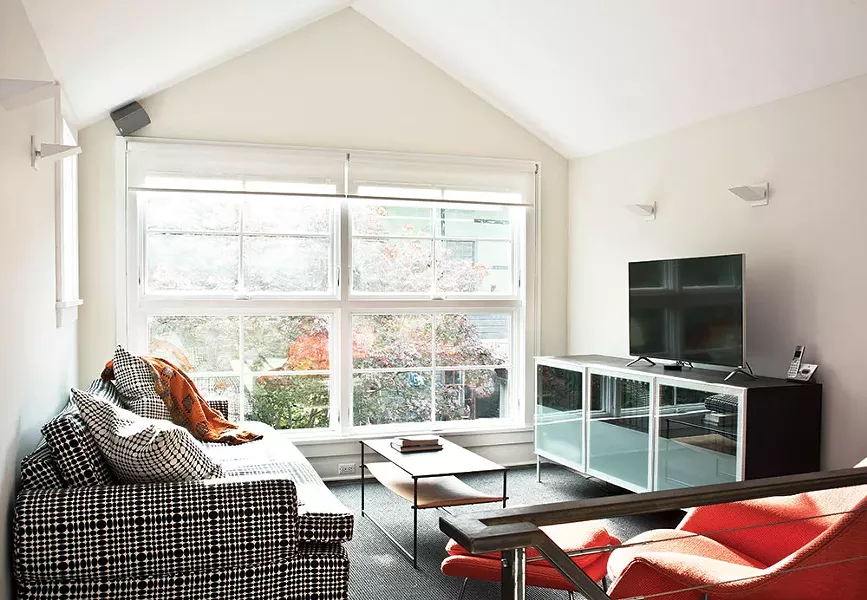 Smith added awning windows in the back of the house overlooking the garden, deck, and carriage house. The windows give a feeling of open space to both floors. “Even in a rainstorm we can keep the windows open and feel the outside,” Smith says. - DEBORAH DEGRAFFENREID