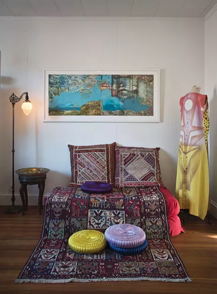 Antonia, one of Khorramian’s paintings of oil on polypropylene created in 2006, hangs next to a hand painted raw silk tunic from Laloon. Pillows and a traditional handcrafted Iranian carpet sit below. - DEBORAH DEGRAFFENREID