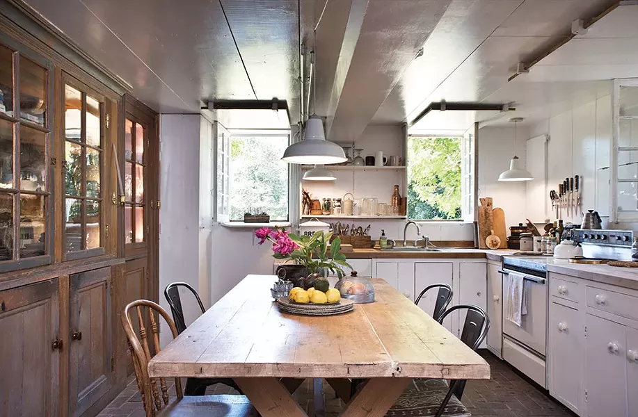 The couple found a 19th-century Swedish farm table for the downstairs kitchen and Doornbos restored the wood counters. The glass hutch is original to the house. - DEBORAH DEGRAFFENREID