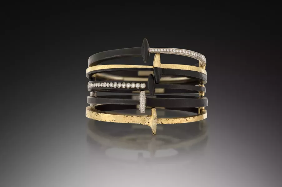 A stack of Pat Flynn's iconic nail bracelets, made with blackened steel, 22k gold, and diamonds.