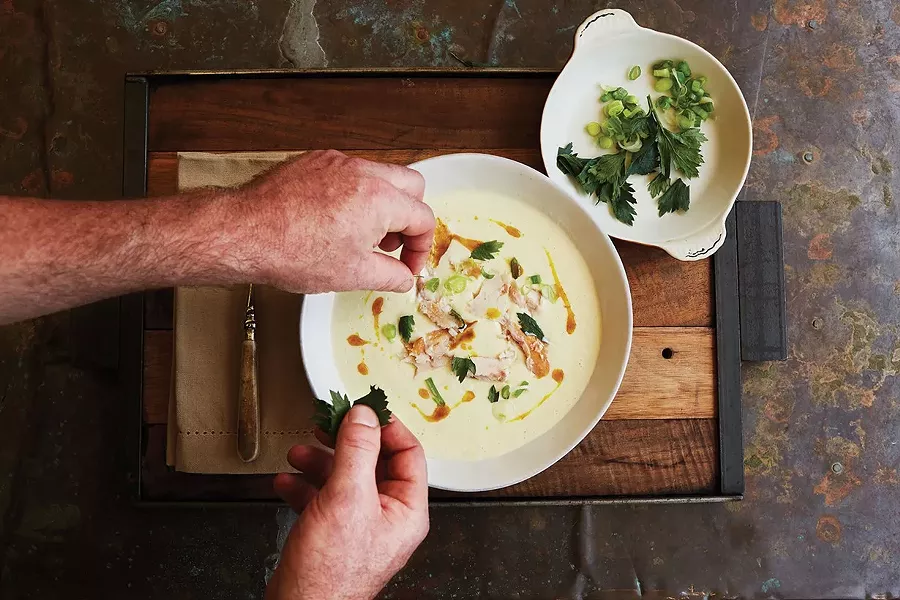 Binnekill Tavern chef Bryan Calvert plating smoked trout soup with crispy parsley. - NATALIE CHITWOOD