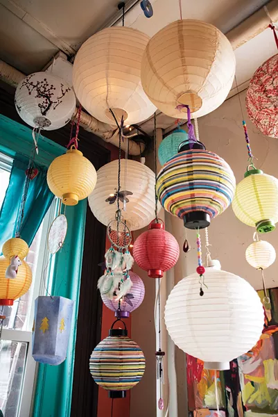 The hanging installation includes gifts from her mother, crafts created by her daughter, and found objects —each one meaningful in its own way. “It was all stuff jammed up in a junk drawer,” she remembers. “I thought, so why not make it art?” - PHOTO BY DEBORAH DEGRAFFENREID