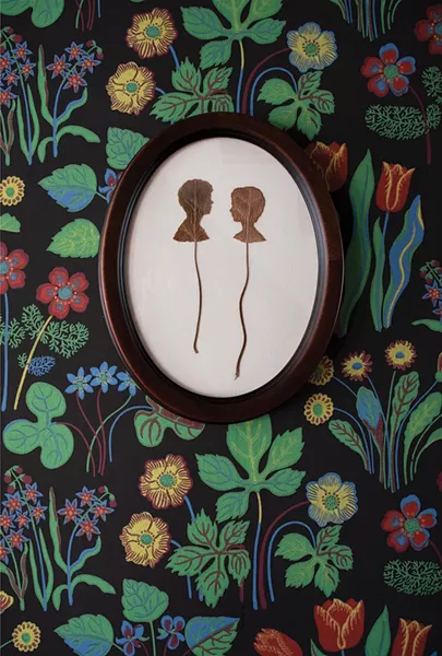 A hallway wall of the Walker family’s renovated Victorian. Marla Walker chose a floral printed wallpaper by Swedish Designer Josef Frank - to cover the central hallway and stairwell up to the second floor. The portrait silhouettes by Catskills-based artist Jenny Lee Fowler are cut from leaves. - PHOTO: DEBORAH DEGRAFFENREID