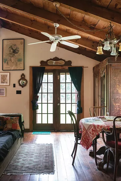 Year by year, as his success as a designer - grew, Blue added onto the house, always trying to stay true to the home’s original spirit. After a fire in the late ’80s, he added this downstairs dining area with vaulted ceilings and installed salvaged French doors from Zaborski’s Emporium in Kingston. He also - added a new exterior deck. “I renovated it in stages of my life,” he says. - PHOTO: DEBORAH DEGRAFFENREID