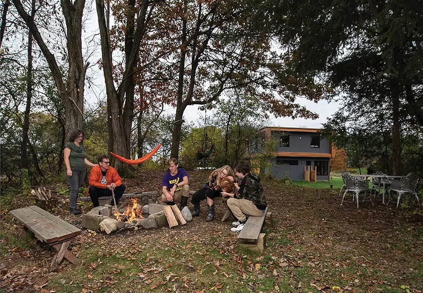 Schmidt, Neiro, and their children at the fire pit and ad-hoc outdoor seating area they created in a grove of trees. “One of the wonderful things about having Sequoia as a partner is that I’ve never had to not have my past,” says Schmidt. “I’ve always had the space to mourn, to acknowledge it, and then to move on. This house has been a chance to create something new and wonderful without having to pretend that 19 years of my life before didn’t exist. This is a really wonderful present and future.” - PHOTO: DEBORAH DEGRAFFENREID
