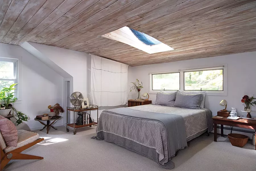 The couple outfitted the home’s upstairs’ master suite as space for guests and dubbed it the Catbird Cottage. The room is decorated with pieces inherited from Hammer’s grandmother, including a Swedish tablecloth. “We’re not really white linen tablecloth kind of people,” explains - Hammer. They hung it on the wall. - PHOTO: DEBORAH DEGRAFFENREID