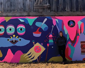 Macon Reed in front of her recently completed mural at Stoneleaf Retreat in Eddyville