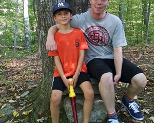 Sam Hollman, age 8, gives Johan Fridlund, age 18, a tour of the woods behind his house on Fridlund's first day with his American host family