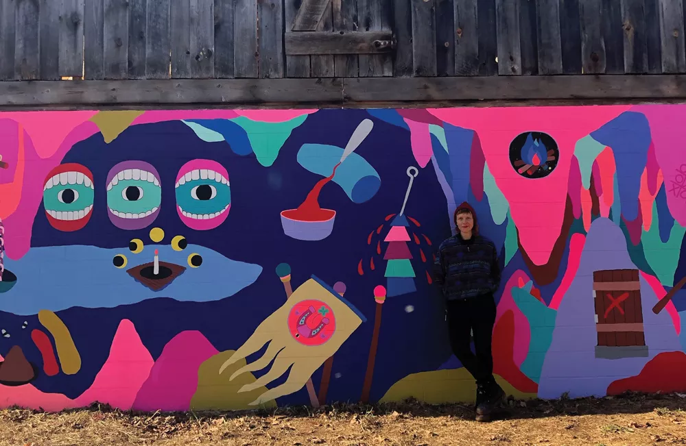 Macon Reed in front of her recently completed mural at Stoneleaf Retreat in Eddyville