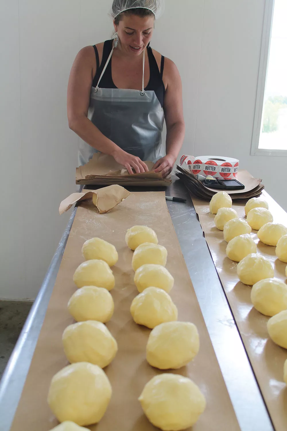 Vermont buttermaker Marisa Mauro of Ploughgate Creamery handwraps and labels her cultured butter. - ELAINE KHOSROVA