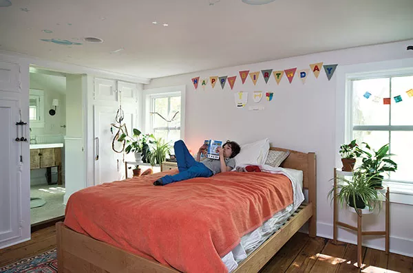 James in his bedroom with en suite bath. The wide-plank wood floors are original to the house; during the remodel, they were sanded and re-stained. - DEBORAH DEGRAFFENREID