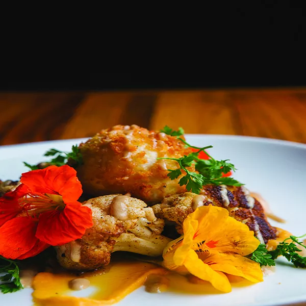 Crispy duck egg with butternut squash puree, roasted cauliflower, nasturtiums, and pine nuts and dressed in black truffle vinaigrette. - THOMAS SMITH