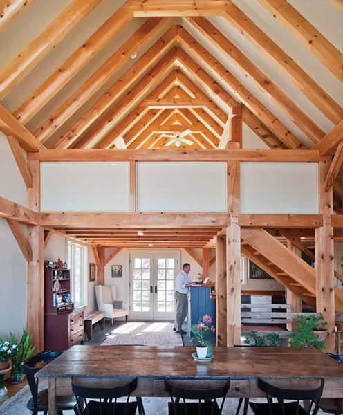 View across dining room table to - kitchen nestled under loft bedroom. - DEBORAH DEGRAFFENREID