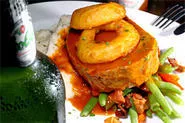 Juicy meatloaf, doused in tangy gravy and resting on a bed of spuds, satisfies manly appetites. - WALTER NOVAK