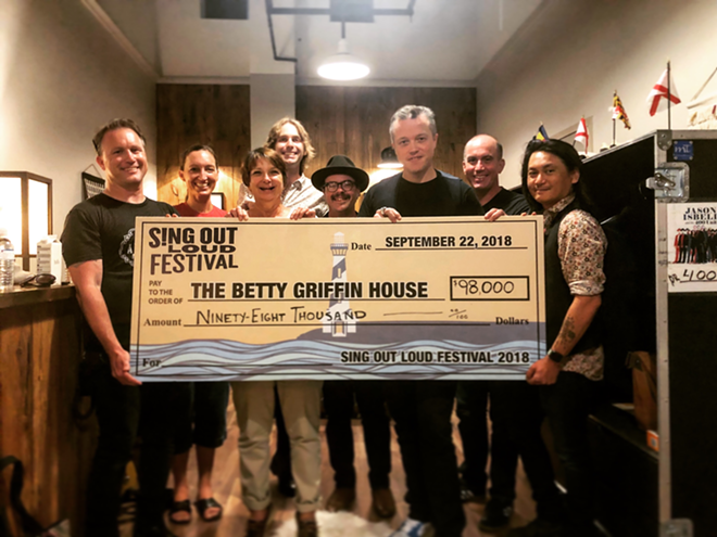 (From left) Ryan Murphy, director of the St. Johns County Cultural Events Division and Amphitheatre general manager, and representatives from Betty Griffin House pictured with Jason Isbell and the 400 Unit. - C/O SING OUT LOUD FESTIVAL