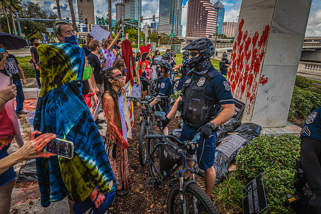 TPD bicycle police defend Tampa's Columbus statue from protesters who put fake blood on it in 2020. - DAVE DECKER