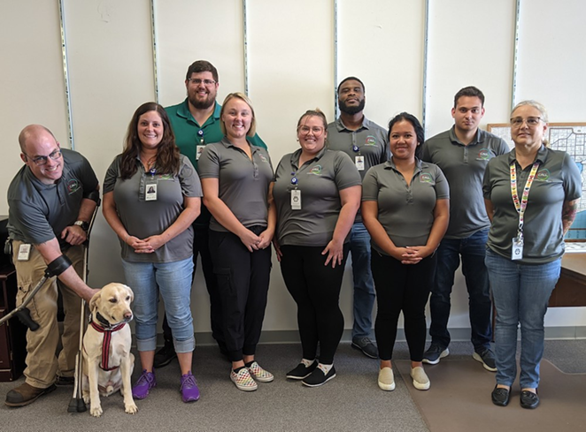 Ender the dog with nine of the 10-person team that makes up St. Petersburg, Florida's CALL team. - JUSTIN GARCIA
