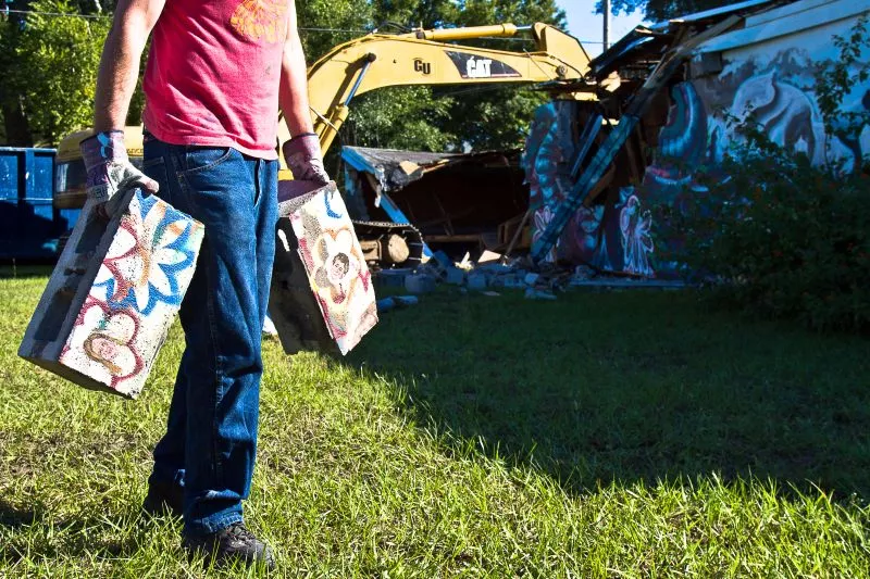 Artist Matt Hebermehl hauls off the remnants of the mural on Habersham and 34th streets. - JON WAITS/@JWAITS