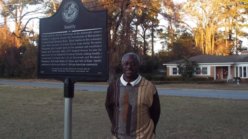 Norman Luten, Jr. is shown at the Sandfly historic marker erected in 2003.
