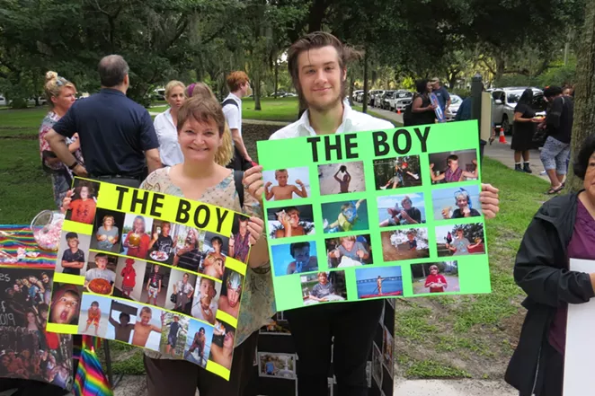 Luke Edenfield (a.k.a. The Boy) escorted by his Aunt Melanie on the first day of Senior year and holding posters filled with precious childhood memories.