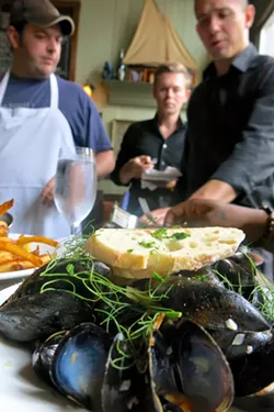 Chef David Landrigan, left, and company enjoy some of their kitchen’s handiwork, in this case the amazing mussels. - PHOTO BY MELISSA DELYNN