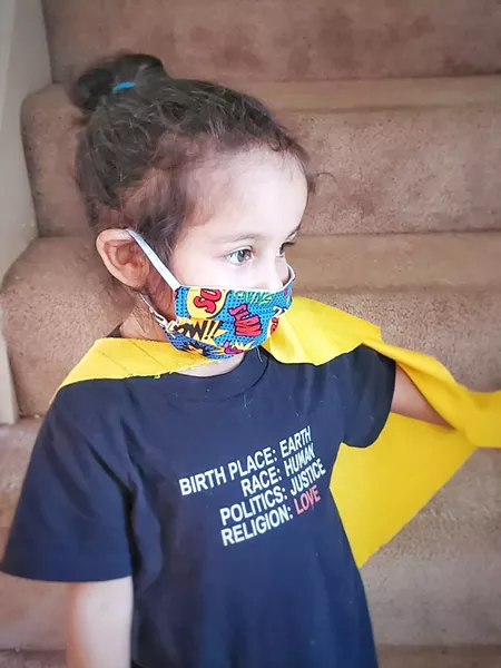 Maya, 3, wears a mask created by her mother Candace Hardnett