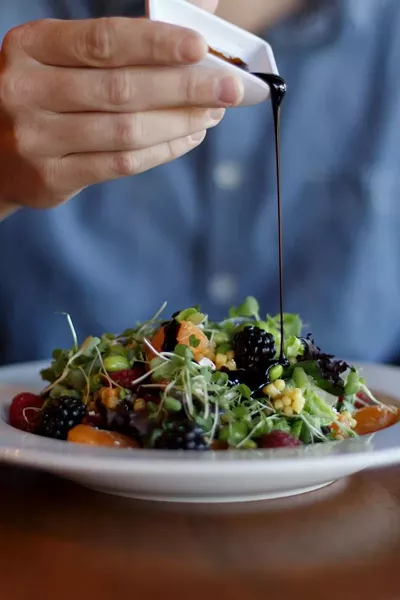 The salad has plump berries, feta, edamame, and a coating of balsamic dressing.