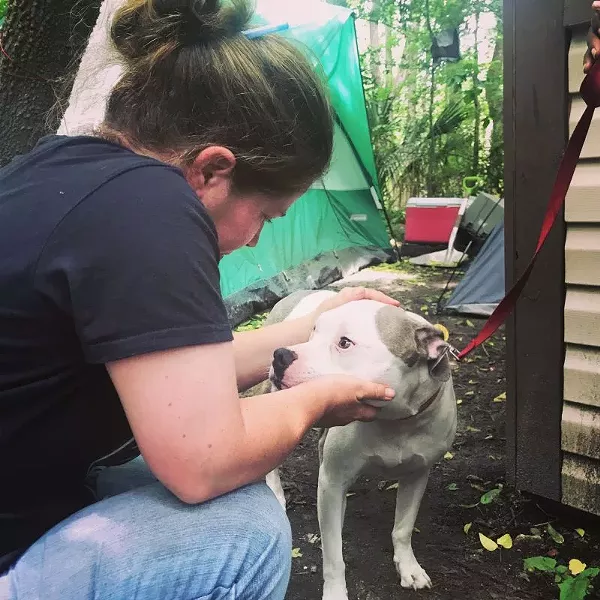 Coastal Pet Rescue Founder/Director Lisa Scarbrough with a friend in one of the camps. - PHOTO COURTESY COASTAL PET RESCUE/JULIA SCHAAF