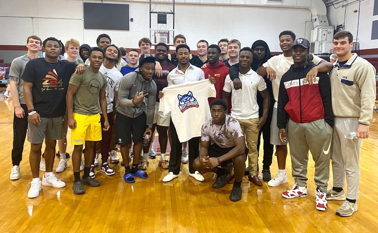 Wesley Kennedy III, center, with Univ. of West Georgia shirt, at his signing event.