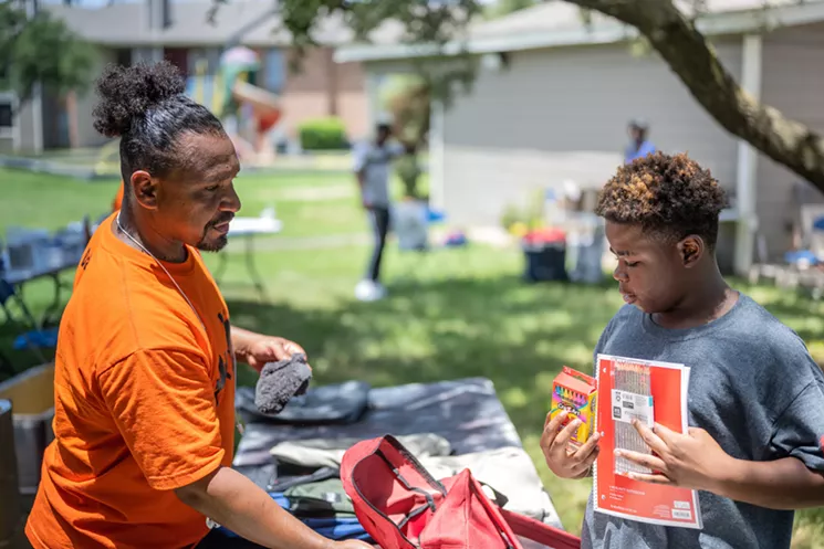 Victor Alvelais offers a young man a backpack and supplies at Chaucer Place Apartments in South Dallas. - MIKE BROOKS