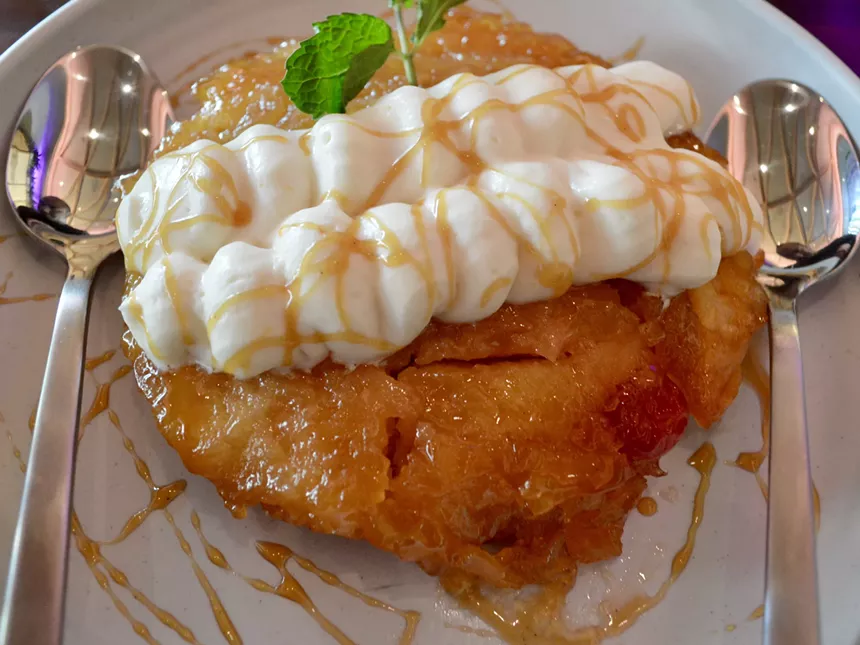 Pineapple upside-down cake topped with whipped cream and a drizzle of caramel - FELICIA LOPEZ