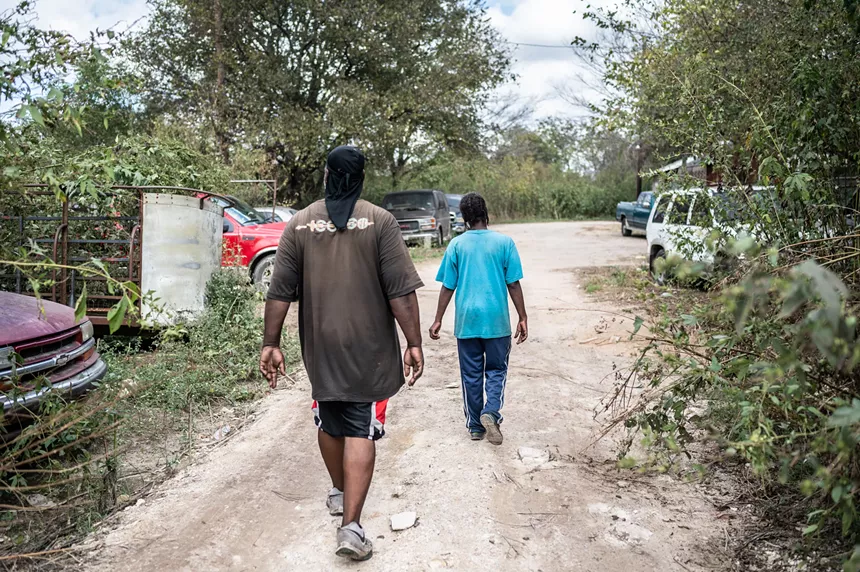 Darwin Shipman (right) and Mahogany Nunnally walk around their property in a part of Sandbranch people call the bottoms. - MIKE BROOKS
