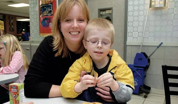 Nichelle Drew and son Kaleb, age seven, got a service dog named Chewey to help Kaleb function well, at home and at school. - PHOTOS BY GINNY LEE