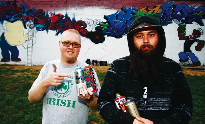 Ryan Wilson (left) and Spencer Stokes show off a graffiti work in progress at Clay’s Popeye’s Barbeque in Springfield. They are part of Total Visual Renewal, a newly created graffiti crew in Springfield.. - PHOTO BY PATRICK YEAGLE