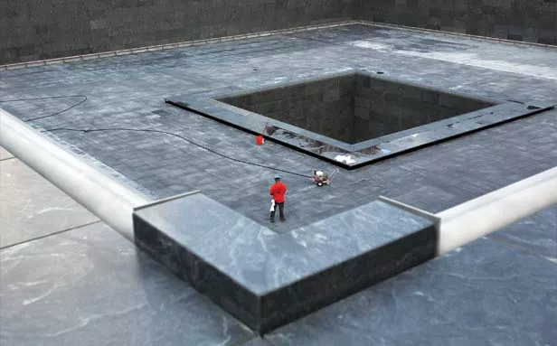 A construction worker stands in the form of the south pool at the National Sept. 11 Memorial in New York City. Bronze panels that ring the memorial’s two pools bear the names of all 9/11 victims, as well as those who died during the 1993 trad - PHOTO BY SCOTT STRAZZANTE/MCT