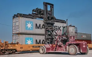 A crane loads a rail car with standardized shipping containers destined for a U.S. coastal port, where they will be loaded onto cargo ships and sent abroad. - PHOTO COURTESY ADM