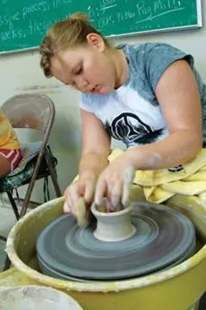 Springfield Art Association Summer Art Camp participant tries her hand at the potter's wheel. - PHOTO BY RICK WADE