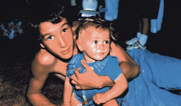 Harold “H.P.” Page III is pictured here holding a nephew, one week before Page was murdered in a stairwell at Ridgely Elementary School.